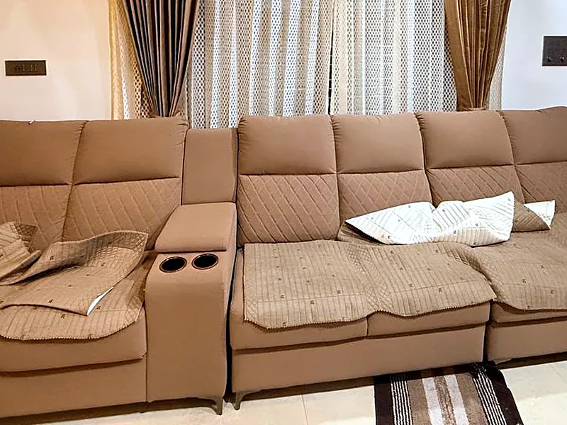 A tan four-seat sofa with a centre console, in a customer's living room