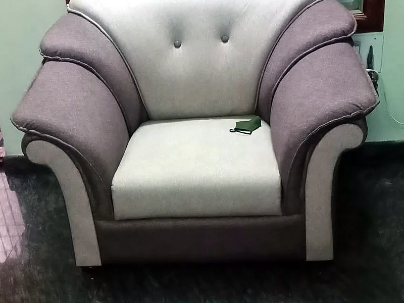 A grey and cream armchair re-covered in a new fabric